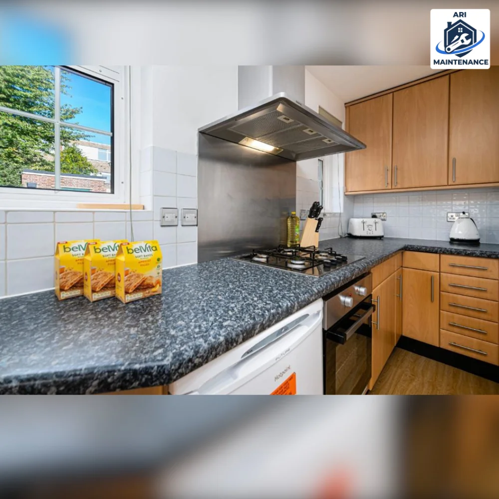 Kitchen refurbishment: wood-front fitted units, dark granite-effect worktop, stainless steel chimney extractor and splashback, five-burner hob and built-in oven